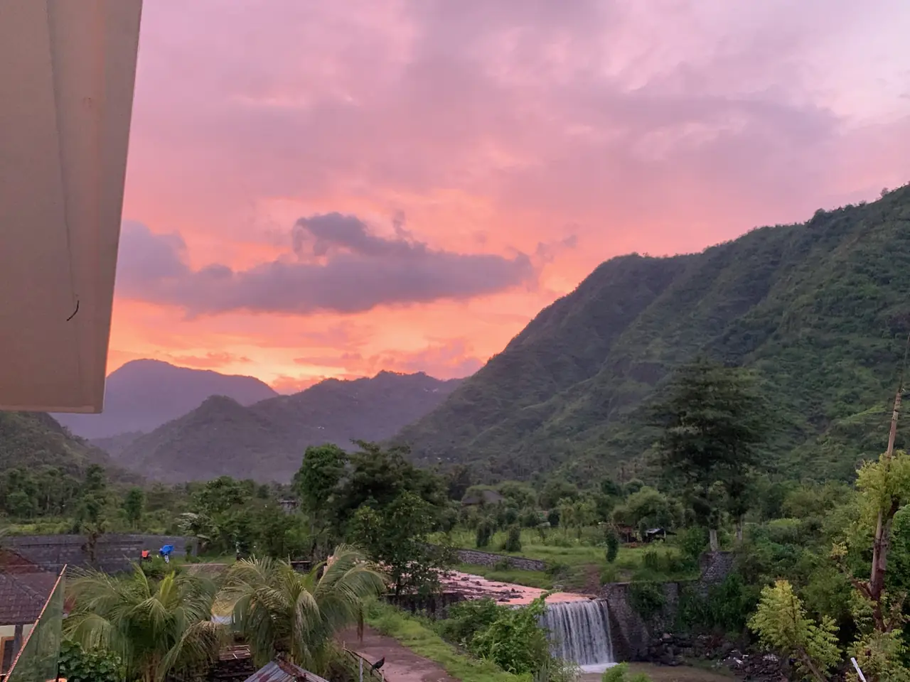 Pink sunset over the valley and waterfall